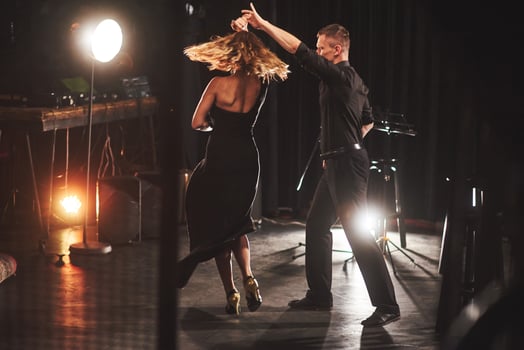 Skillful dancers performing in the dark room under the light photo