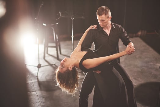 Skillful dancers performing in the dark room under the light photo