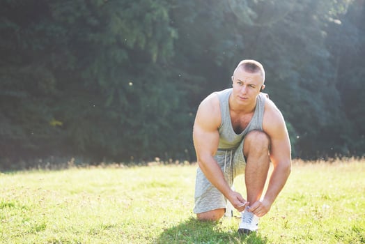 Tying sports shoe. A young sportsman getting ready for athletic and fitness training outdoors. Sport, exercise, fitness, workout. Healthy lifestyle photo