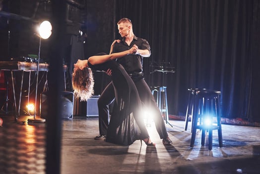 Skillful dancers performing in the dark room under the light photo