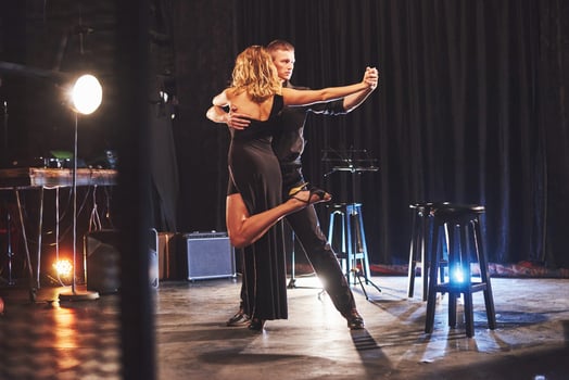 Skillful dancers performing in the dark room under the light photo