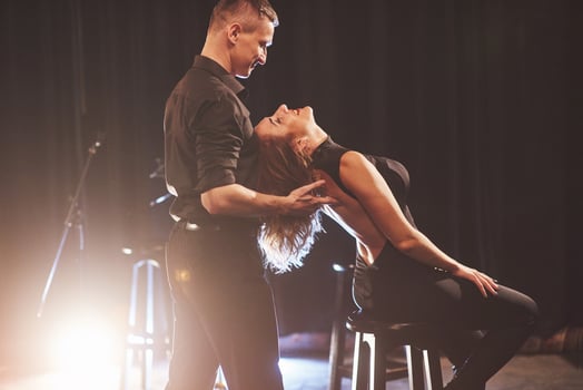 Skillful dancers performing in the dark room under the light photo