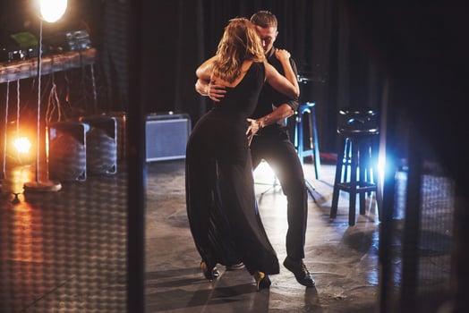 Skillful dancers performing in the dark room under the light photo