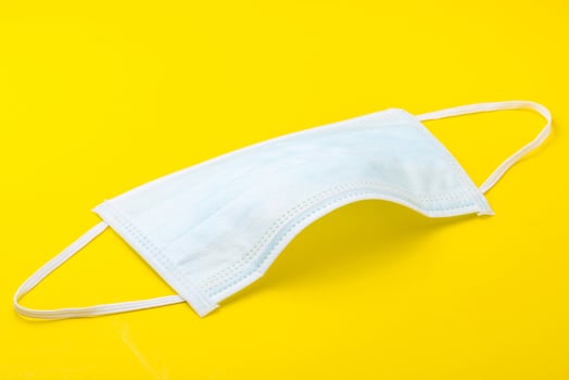 New white mask on yellow background. photo