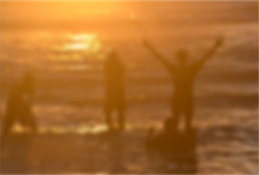 people playing on the beach in the evening blurry photo