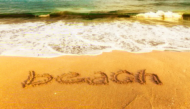 azure ocean with inscription BEACH on the yellow  sand photo