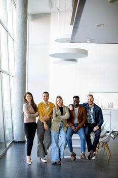 Group of positive businesspeople standing together in the office photo