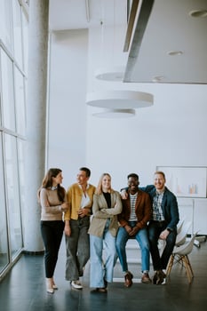 Group of positive businesspeople standing together in the office photo