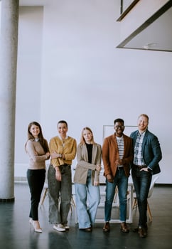 Group of positive businesspeople standing together in the office photo