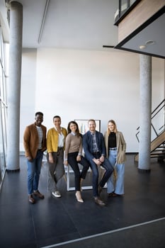 Group of positive businesspeople standing together in the office photo