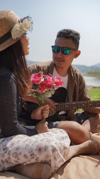 happy young couple playing guitar on vacation at the lake photo