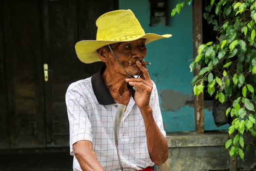 Close up portrait of Asian Javanese old man with a cigarette in his hand photo