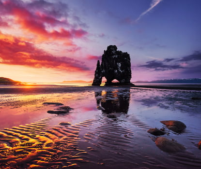 Is a spectacular rock in the sea on the Northern coast of Iceland. Legends say it is a petrified troll. On this photo Hvitserkur reflects in the sea water after the midnight sunset