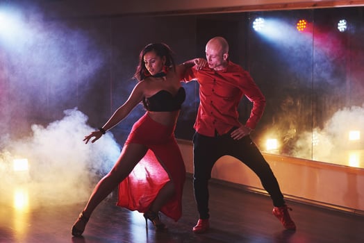Skillful dancers performing in the dark room under the concert light and smoke. Sensual couple performing an artistic and emotional contemporary dance photo