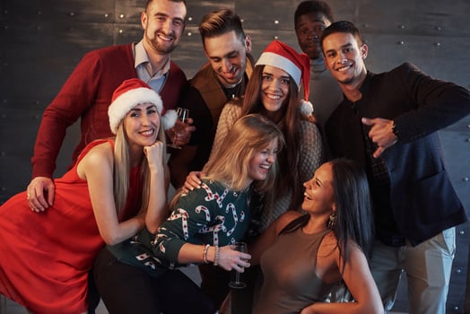 New Year is coming. Group of cheerful young multiethnic people in Santa hats on the party, posing emotional lifestyle people concept photo