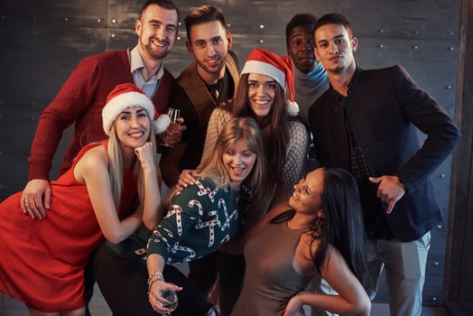 New Year is coming. Group of cheerful young multiethnic people in Santa hats on the party, posing emotional lifestyle people concept photo