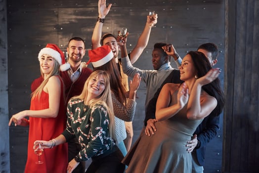Party with friends. They love Christmas. Group of cheerful young people carrying sparklers and champagne flutes dancing in new year party and looking happy. Concepts about togetherness lifestyle photo