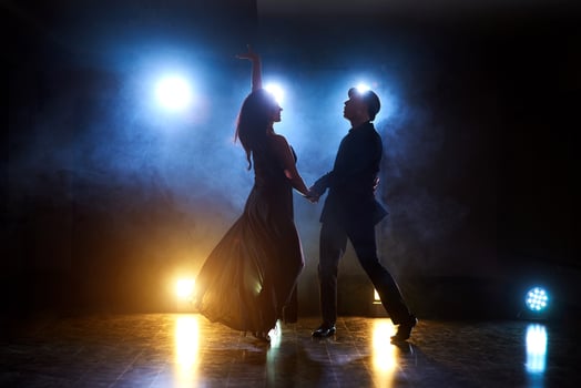 Skillful dancers performing in the dark room under the concert light and smoke. Sensual couple performing an artistic and emotional contemporary dance photo