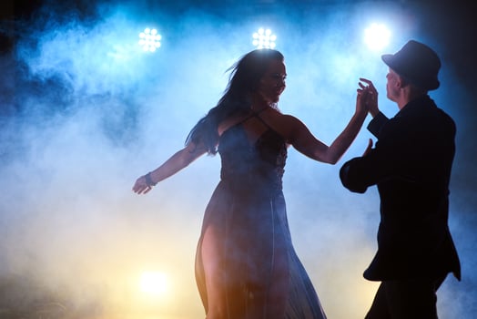 Skillful dancers performing in the dark room under the concert light and smoke. Sensual couple performing an artistic and emotional contemporary dance photo