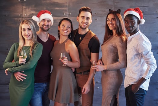New Year is coming. Group of cheerful young multiethnic people in Santa hats on the party, posing emotional lifestyle people concept photo