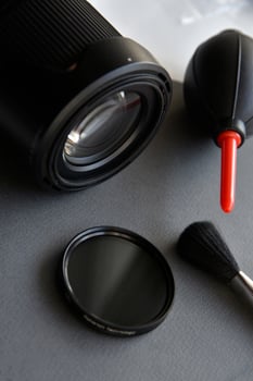Cleaning photo lenses with a brush and a pear