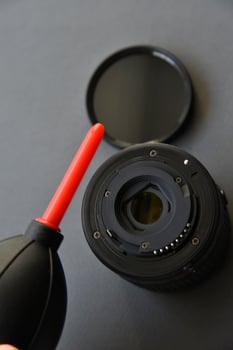Cleaning photo lenses with a brush and a pear