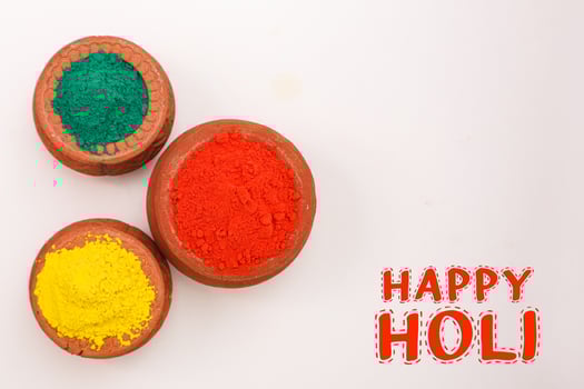 Indian festival Holi concept Multi color's bowl with colorful background and writing happy holi photo