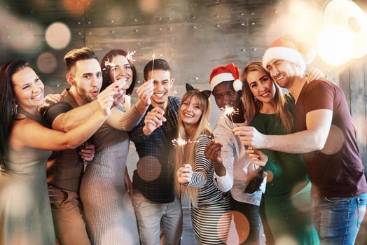 Party with friends. Group of cheerful young people carrying sparklers and champagne flutes. Bokeh light soft effect. photo