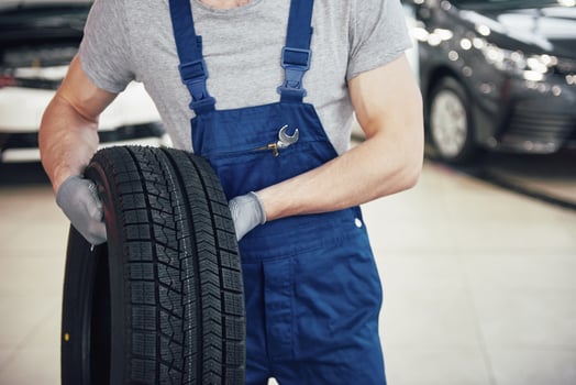 Mechanic holding a tire tire at the repair garage. replacement of winter and summer tires photo