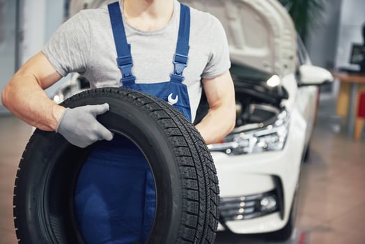 Mechanic holding a tire tire at the repair garage. replacement of winter and summer tires photo