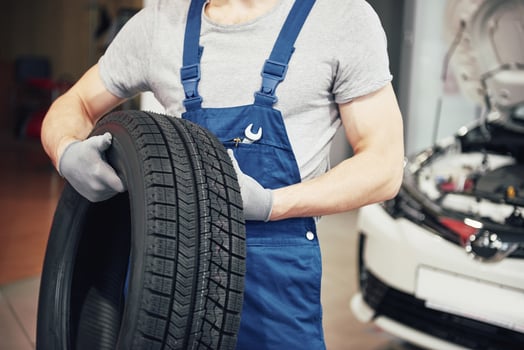 Mechanic holding a tire tire at the repair garage. replacement of winter and summer tires photo