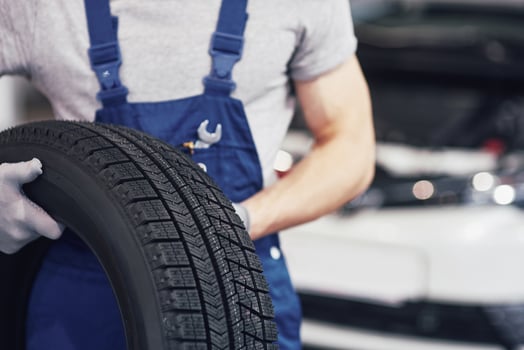 Mechanic holding a tire tire at the repair garage. replacement of winter and summer tires photo