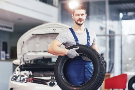 Mechanic holding a tire tire at the repair garage. replacement of winter and summer tires photo