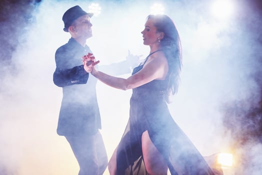 Skillful dancers performing in the dark room under the concert light and smoke. Sensual couple performing an artistic and emotional contemporary dance photo