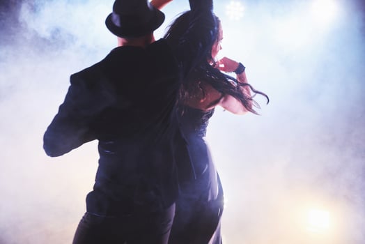 Skillful dancers performing in the dark room under the concert light and smoke. Sensual couple performing an artistic and emotional contemporary dance photo