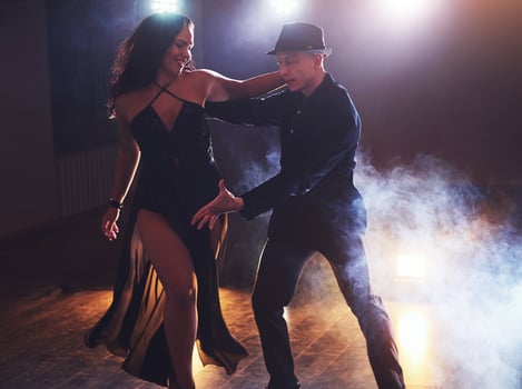 Skillful dancers performing in the dark room under the concert light and smoke. Sensual couple performing an artistic and emotional contemporary dance photo