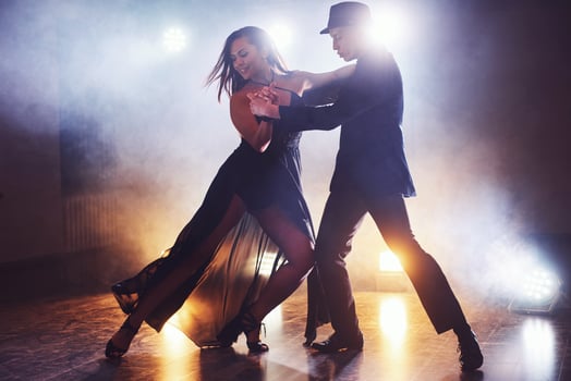Skillful dancers performing in the dark room under the concert light and smoke. Sensual couple performing an artistic and emotional contemporary dance photo