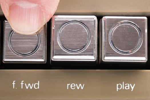 Finger pressed a forward button of a vintage tape recorder macro photo