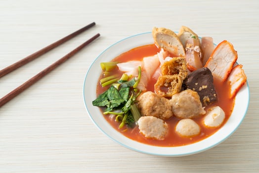 noodles with meatballs in pink soup photo
