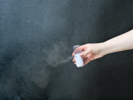 hand holding travel usb mist sprayer for air humudifying and moisturizing skin. mini humidifier for face hydrating and skin care photo