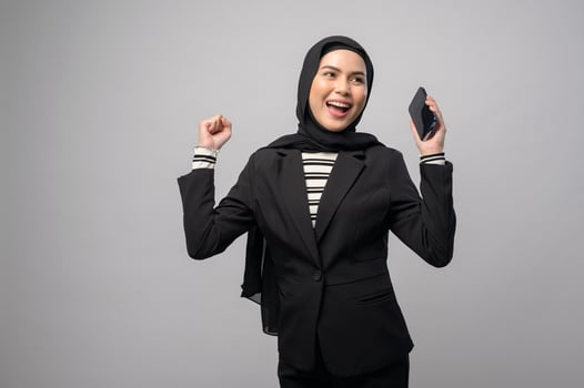 Portrait of beautiful woman with hijab using cellphone on white background photo
