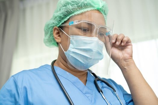 Asian doctor wearing face shield and PPE suit new normal to check patient protect safety infection Covid 19 Coronavirus outbreak at quarantine nursing hospital ward. photo