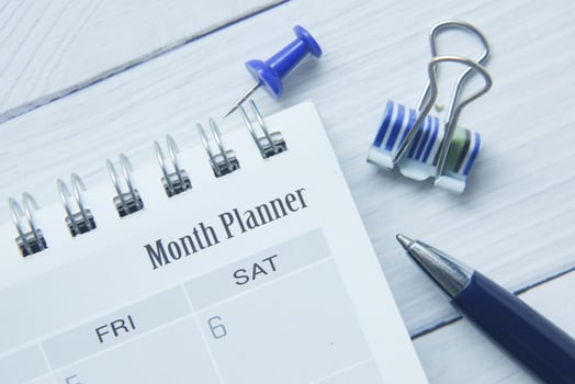 monthly planner and stationary on table photo