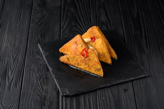 Fried tofu with pineapple on a black wooden background. photo