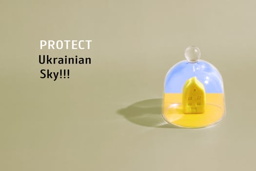 Yellow-blue house as symbol of Ukraine under a glass cap and a call to close the sky over Ukraine. photo