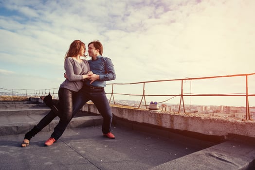 young couple dancing on the roof of a tall building photo
