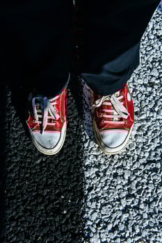 pair red shoe on the pavement. Black asphalt texture photo