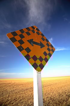Road sign in front of a combined Saskatchewan field photo