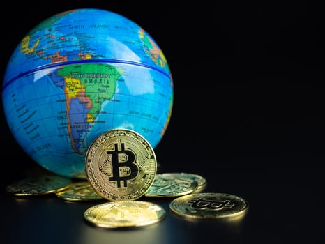 Bitcoin Coins Placed Ahead of a Model World on a black background photo