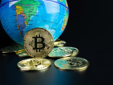 Bitcoin Coins Placed Ahead of a Model World on a black background photo